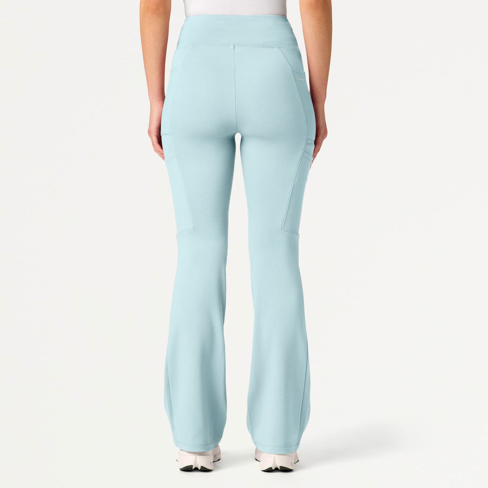 Sky blue scrub pants worn by a woman on a white background
