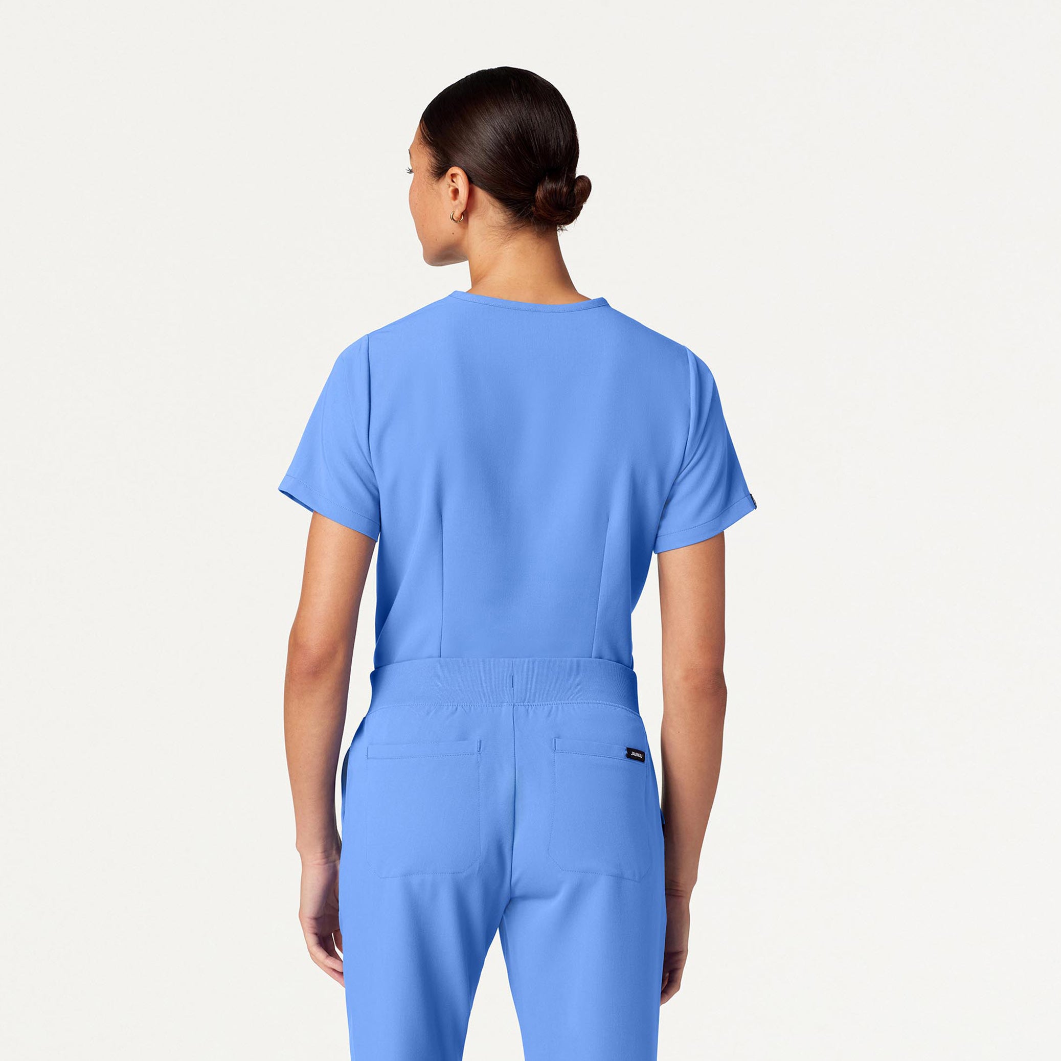 Person wearing a blue scrub set on a white background