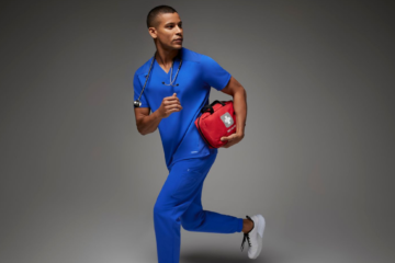 Man wearing blue scrubs carrying first aid kit