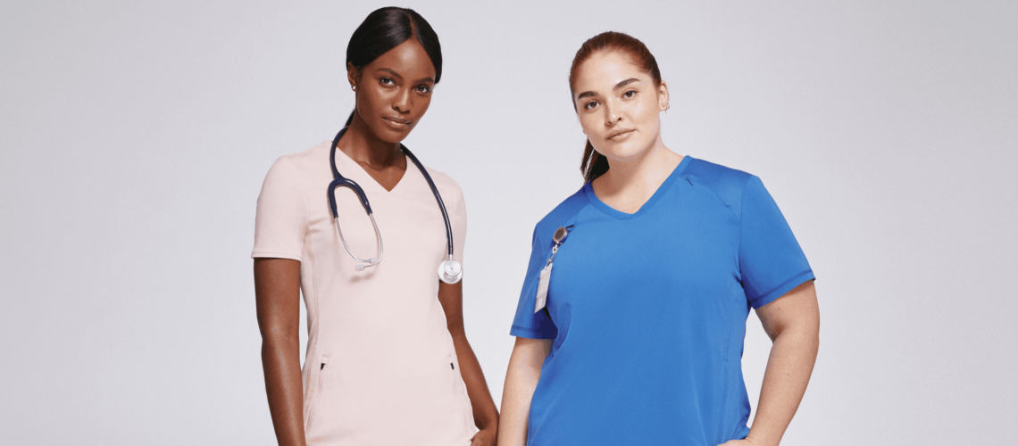 Women wearing mesh panel top scrubs in pink and blue
