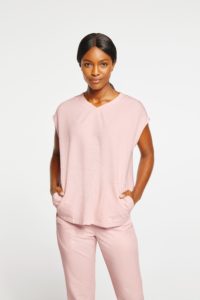 Woman wearing pink pocket top and pants scrubs
