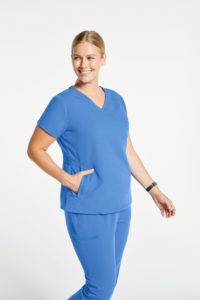 Plus woman wearing pocket mock wrap top scrubs in blue.jpg