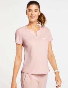 Woman wearing one pocket tuck in top scrub in light pink