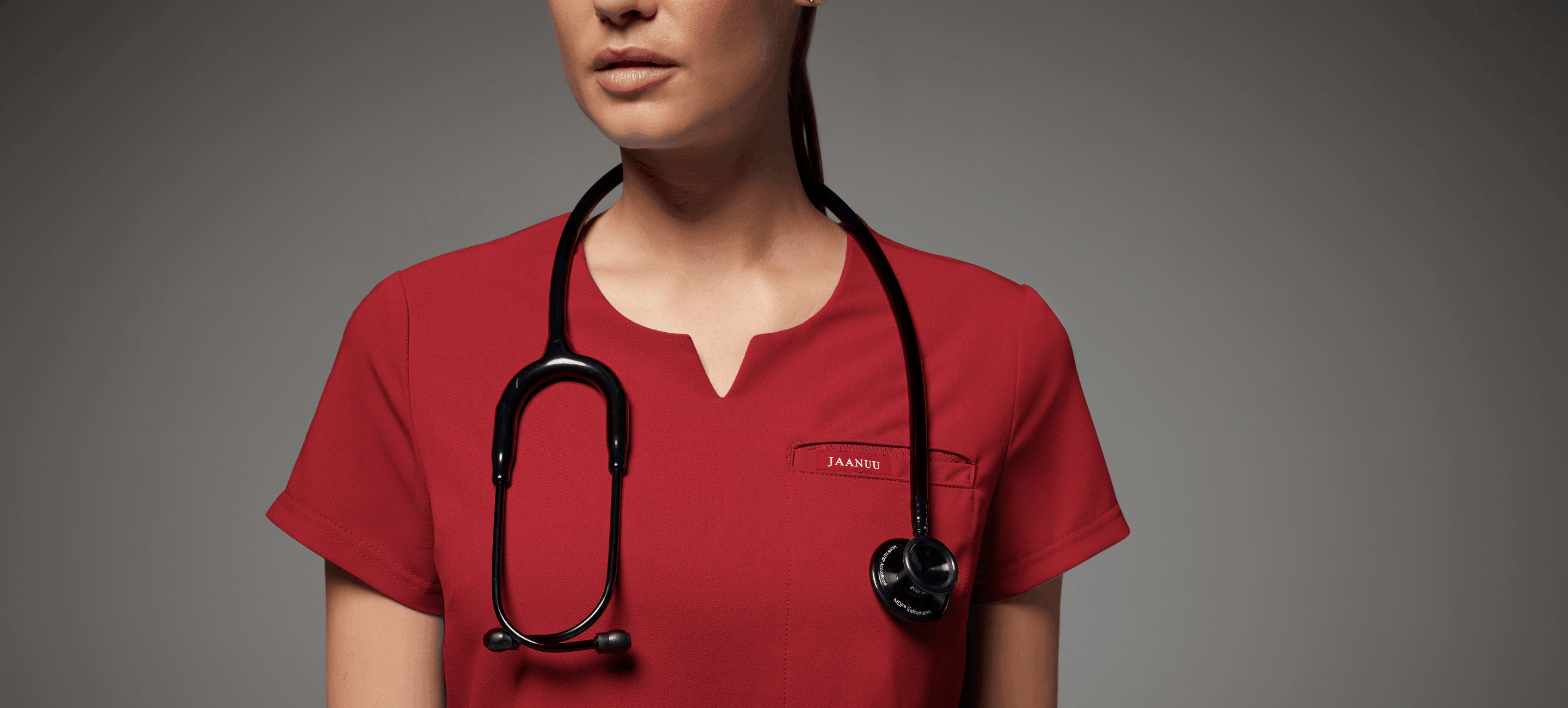 https://www.jaanuu.com/blog/wp-content/uploads/2022/05/Nurse-wearing-jaanuu-wine-scrubs-and-stethoscope.png