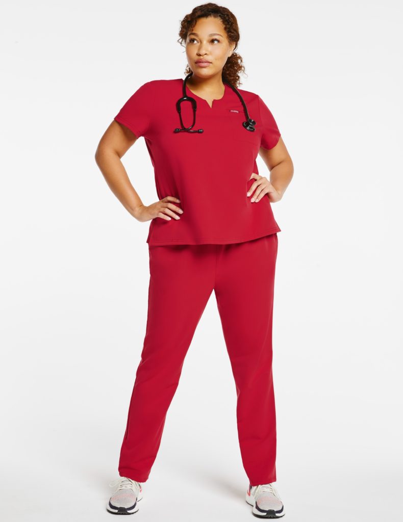 Plus woman wearing red jaanuu notched top scrubs