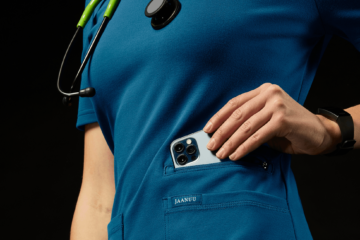 health professional in blue scrubs with wrist device and phone in hand
