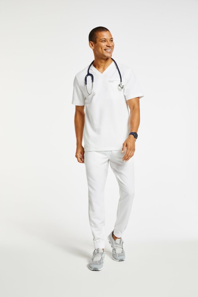 Male nurse wearing white scrubs with stethoscope and smiling