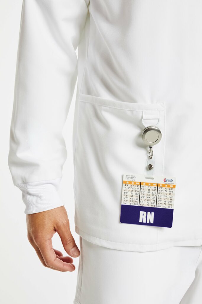 white scrub jacket with nurse badge hanging on its pocket