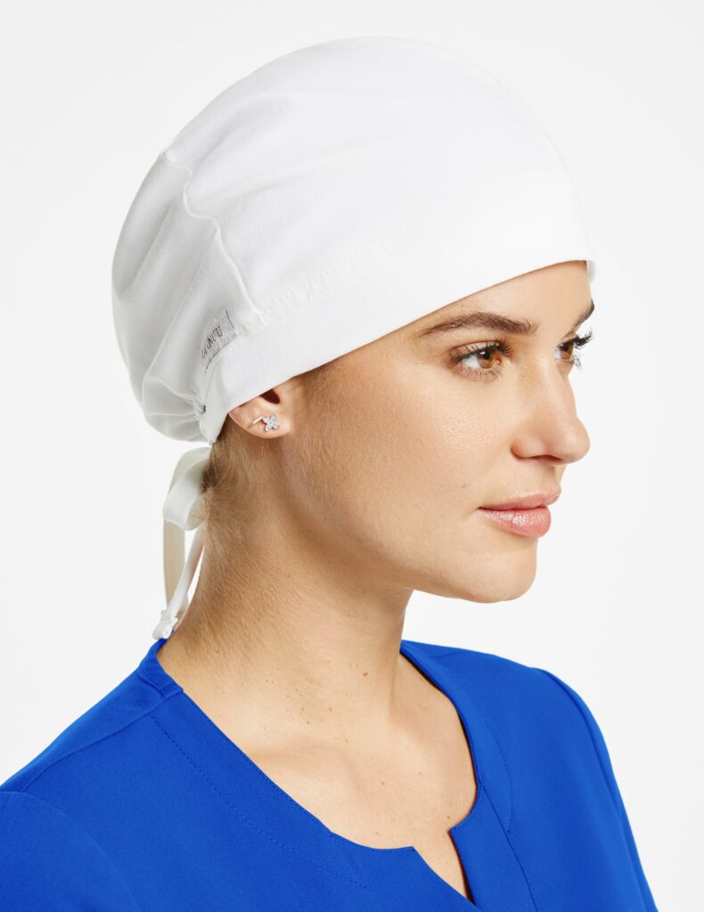 female surgical nurse wearing white scrub cap and blue scrub top