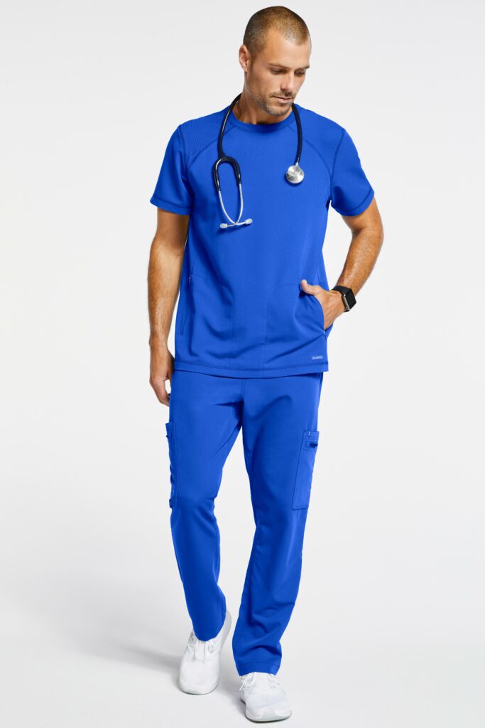 Male surgical nurse wearing blue scrubs and a black stethoscope on his neck