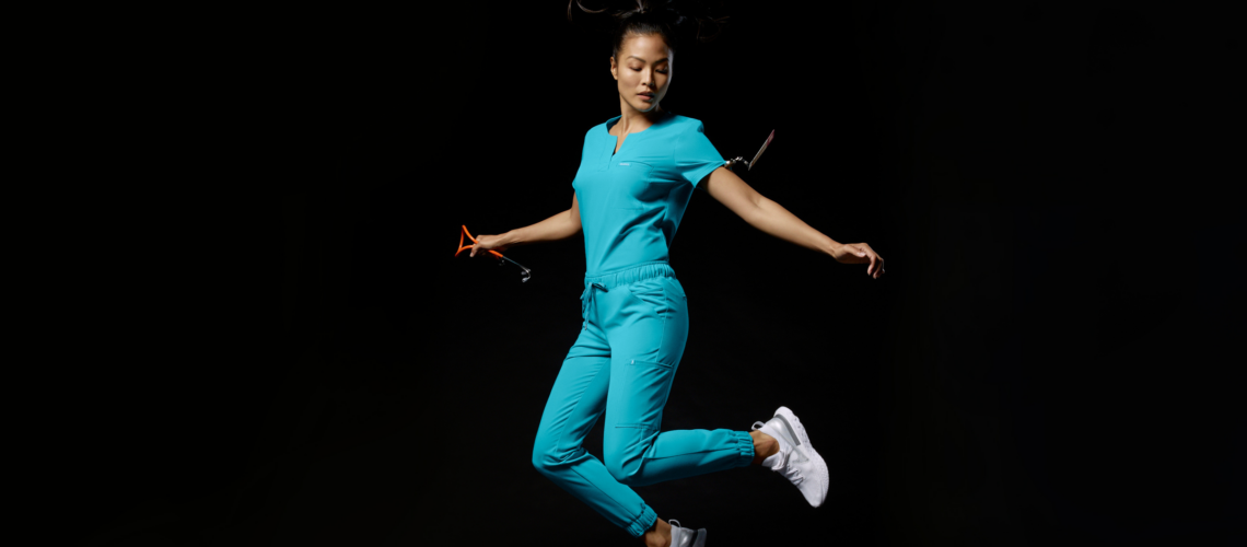 nurse-jumping-black-background-wearing-jaanuu-scrubs