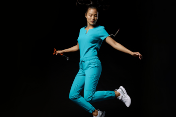 nurse-jumping-black-background-wearing-jaanuu-scrubs