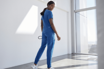 nurse-wearing-blue-jaanuu-scrubs-white-room