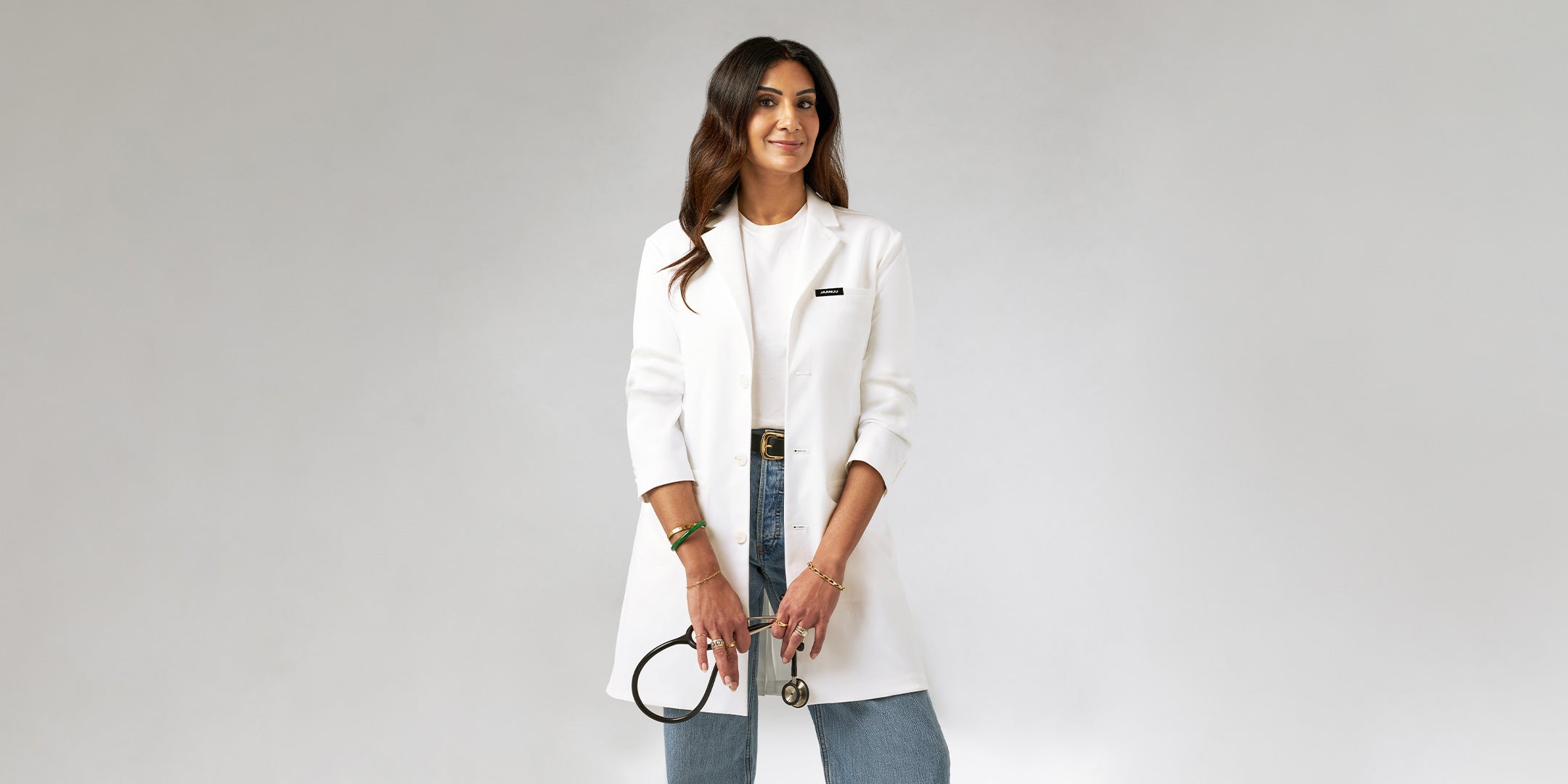 Dr. Neela wearing a lab coat while holding a stethosope.