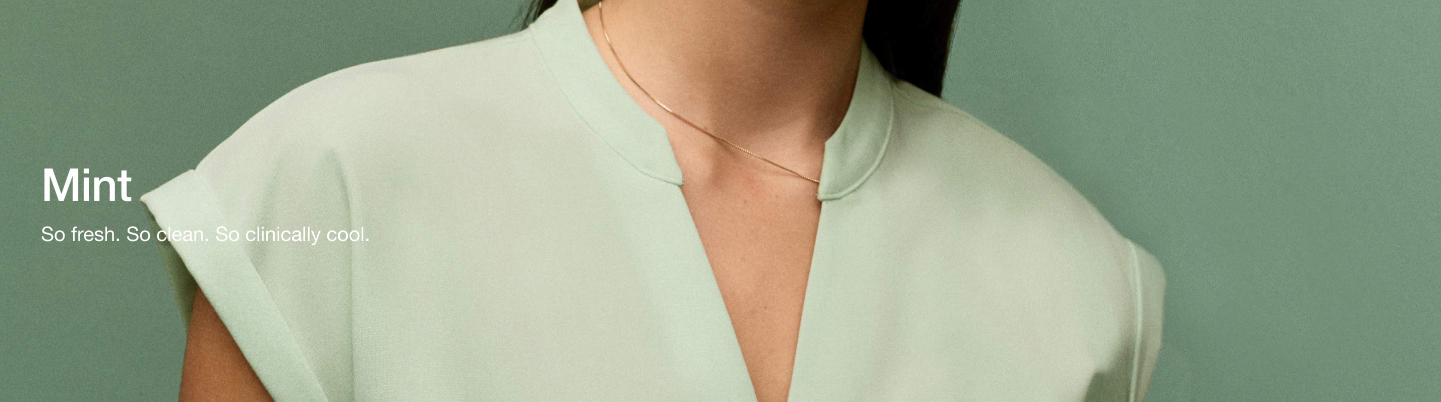A woman wearing JAANUU Mint colored scrub top. Image has text saying, "Mint: So fresh. So clean. So clinically cool."