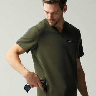 A man wearing JAANUU Deep Olive colored scrubs. - Men Nav Tile