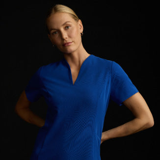 A woman wearing JAANUU scrubs in Galaxy color. - Women Nav Tile