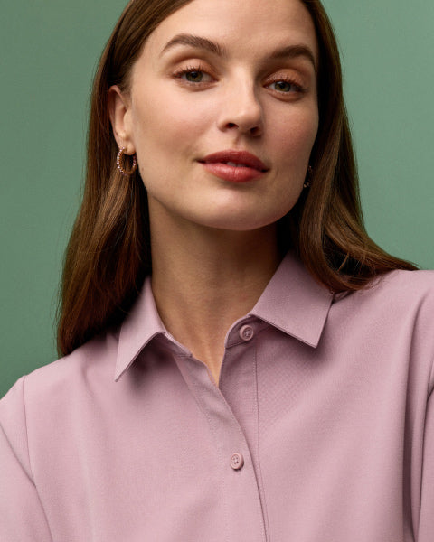 A women wearing a JAANUU collared scrub top. - Women Nav Tile