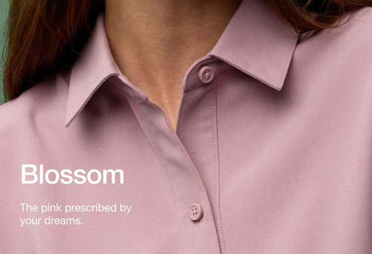 Image of woman wearing JAANUU Blossom colored scrubs. Image has text saying, "Blossom: The pink prescribed by your dreams."