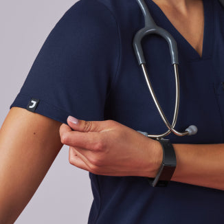 A women wearing JAANUU UltraSOFT scrubs. - Women Nav Tile