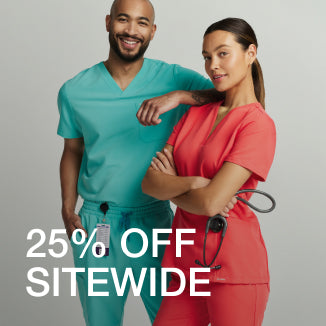 Man wearing a surf teal Jaanuu scrub top and woman wearing a coral Jaanuu scrub top standing together, with text '25% Off Sitewide' - Women Nav Tile