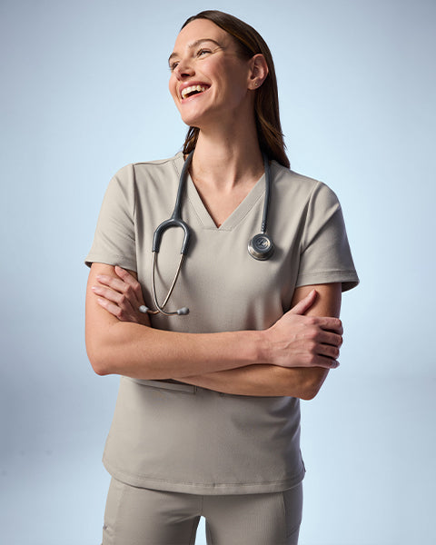 Woman wearing Fog color scrubs. - Women Nav Tile