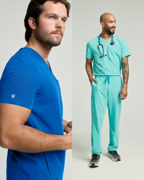 A man in a royal blue Jaanuu scrub top beside a man in a mint green Jaanuu scrub set with a stethoscope, on a light studio background. - Men Nav Tile