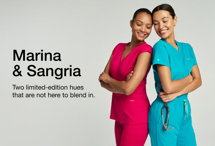 Promotional banner with the text 'Marina & Sangria' and 'Two limited-edition hues that are not here to blend in.' Beside it, two women lean together, one in a hot-pink Sangria scrub top and one in a teal Marina scrub top with a stethoscope.