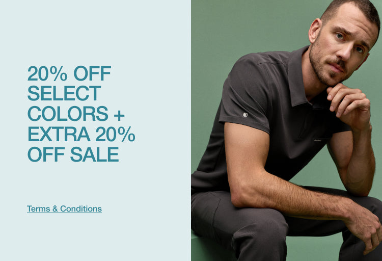 A man in a charcoal Jaanuu polo-style scrub top resting his hand on his chin against a green backdrop, with text '20% Off Select Colors + Extra 20% Off Sale' and a 'Terms & Conditions' link.