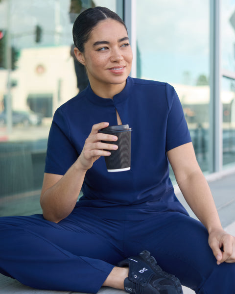 Jaanuu UltraLITE scrubs: a woman wearing the navy UltraLITE mock-neck top and pant. - Women Nav Tile