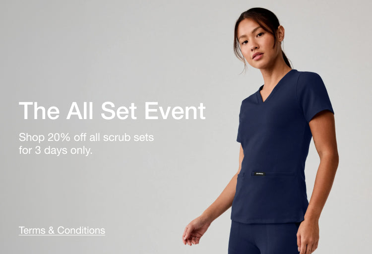 The All Set Event – Shop 20% off all scrub sets for 3 days only. A women wearing Jaanuu scrubs in midnight navy.