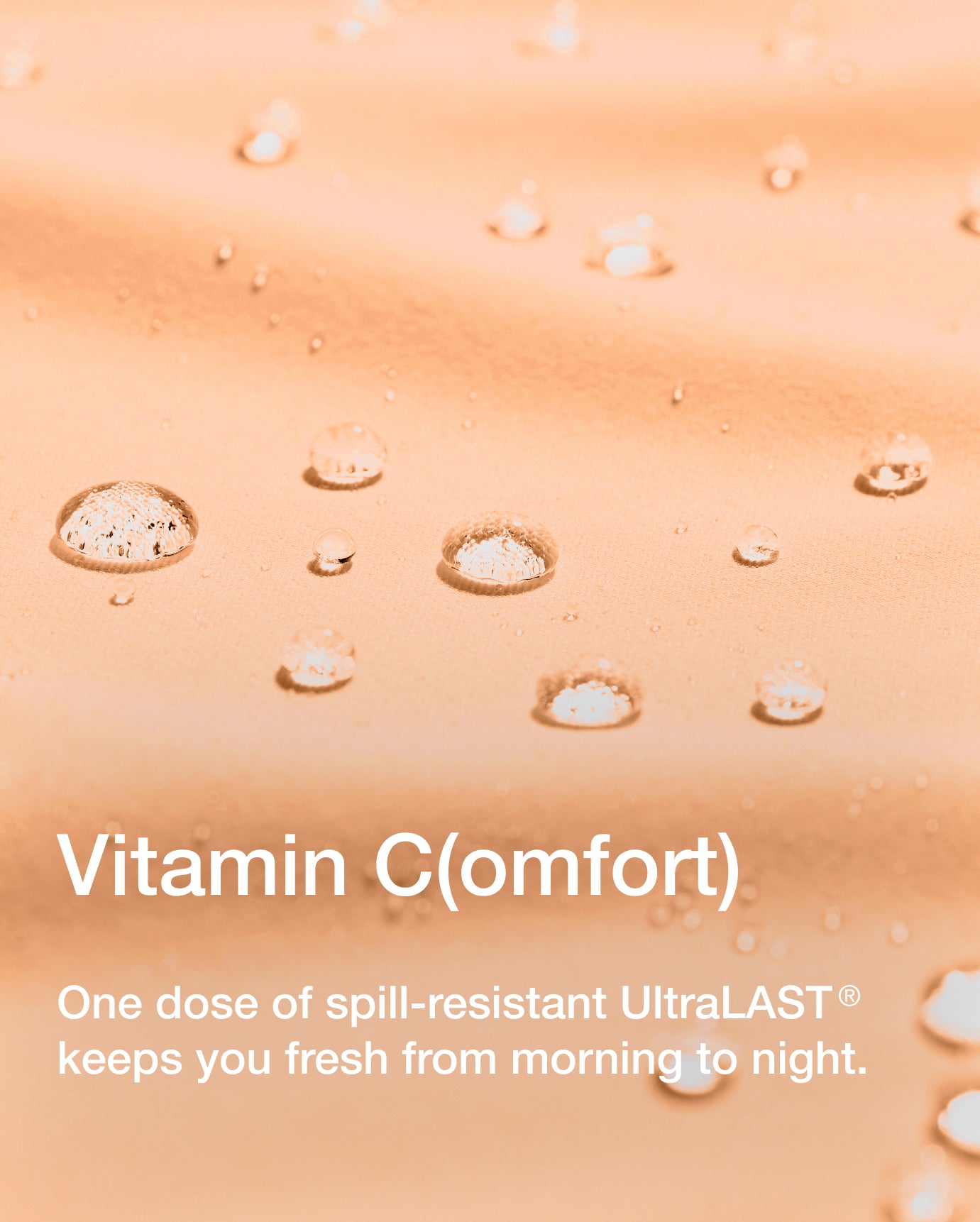 Close-up of a apricot-colored liquid or gel surface with water droplets and white text reading 'Vitamin C(omfort)' and 'One dose of spill-resistant UltraLAST keeps you fresh from morning to night.'.