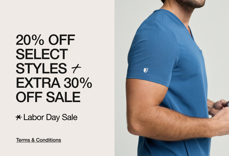 A man in a blue Jaanuu scrub top. Text on the image reads: "20% OFF SELECT STYLES + EXTRA 30% OFF SALE. Labor Day Sale. Terms & Conditions"