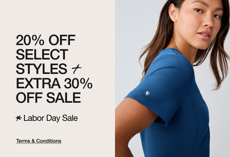 A woman in a blue Jaanuu scrub top. Text on the image reads: "20% OFF SELECT STYLES + EXTRA 30% OFF SALE. Labor Day Sale. Terms & Conditions"