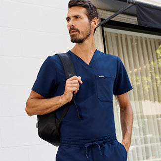 Man wearing slim scrubs with a backpack. - Men Nav Tile