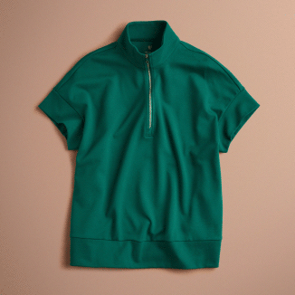 Animated flat lay that alternates between a Hunter Green (dark green) Jaanuu short-sleeve half-zip scrub top and matching flare-leg scrub pants with a zippered leg pocket, on a blush pink background. - Women Nav Tile