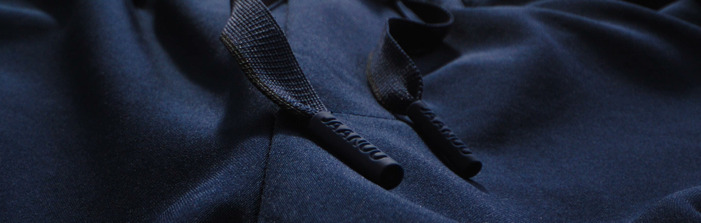 Close view of the drawstring on JAANUU scrub pants, with the JAANUU name on both cord tips