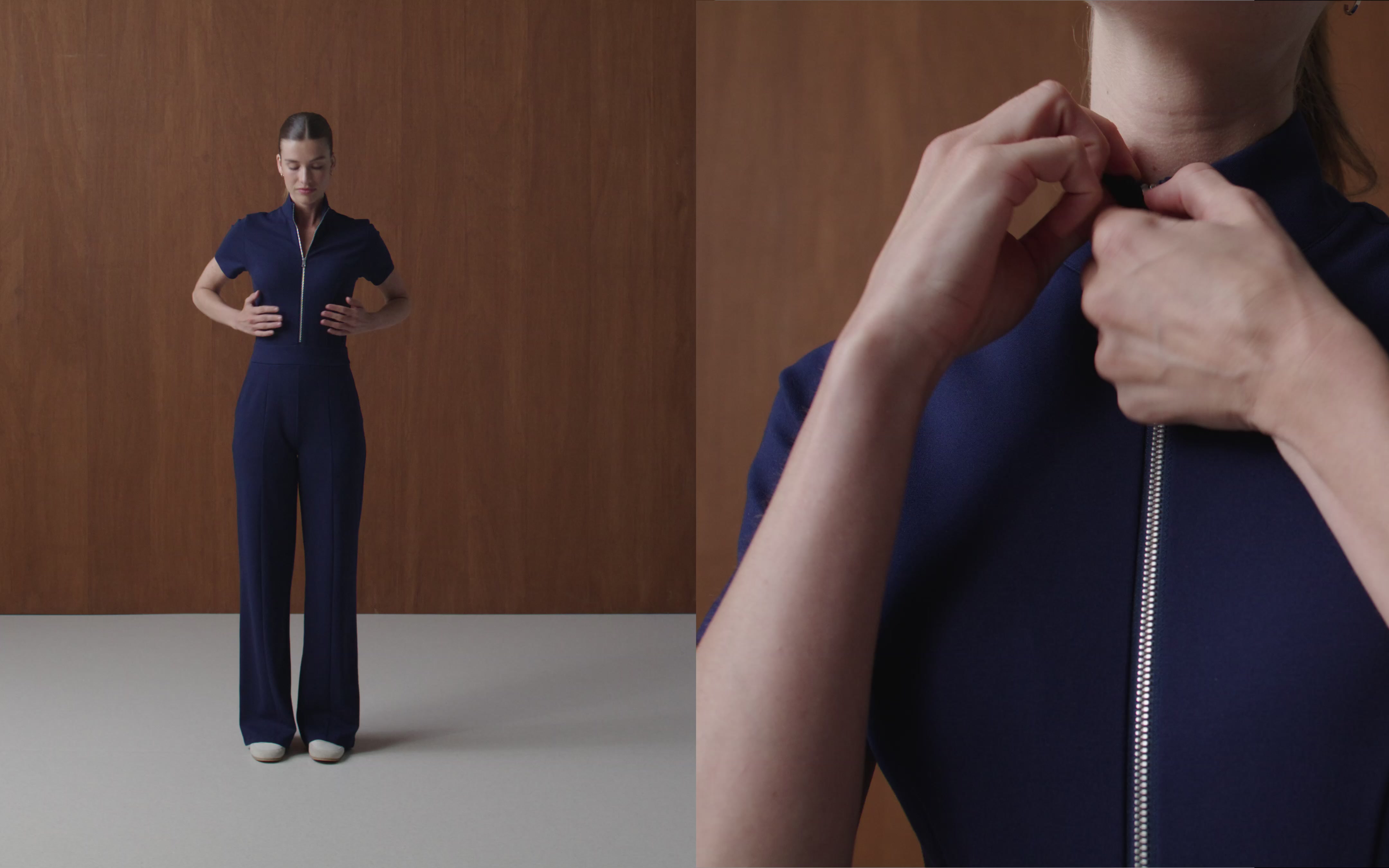 Split frame of a woman in a navy Jaanuu zip-front scrub top and wide-leg scrub pants standing against a wood-panel wall, beside a close-up of her hands pulling the zipper up at the collar