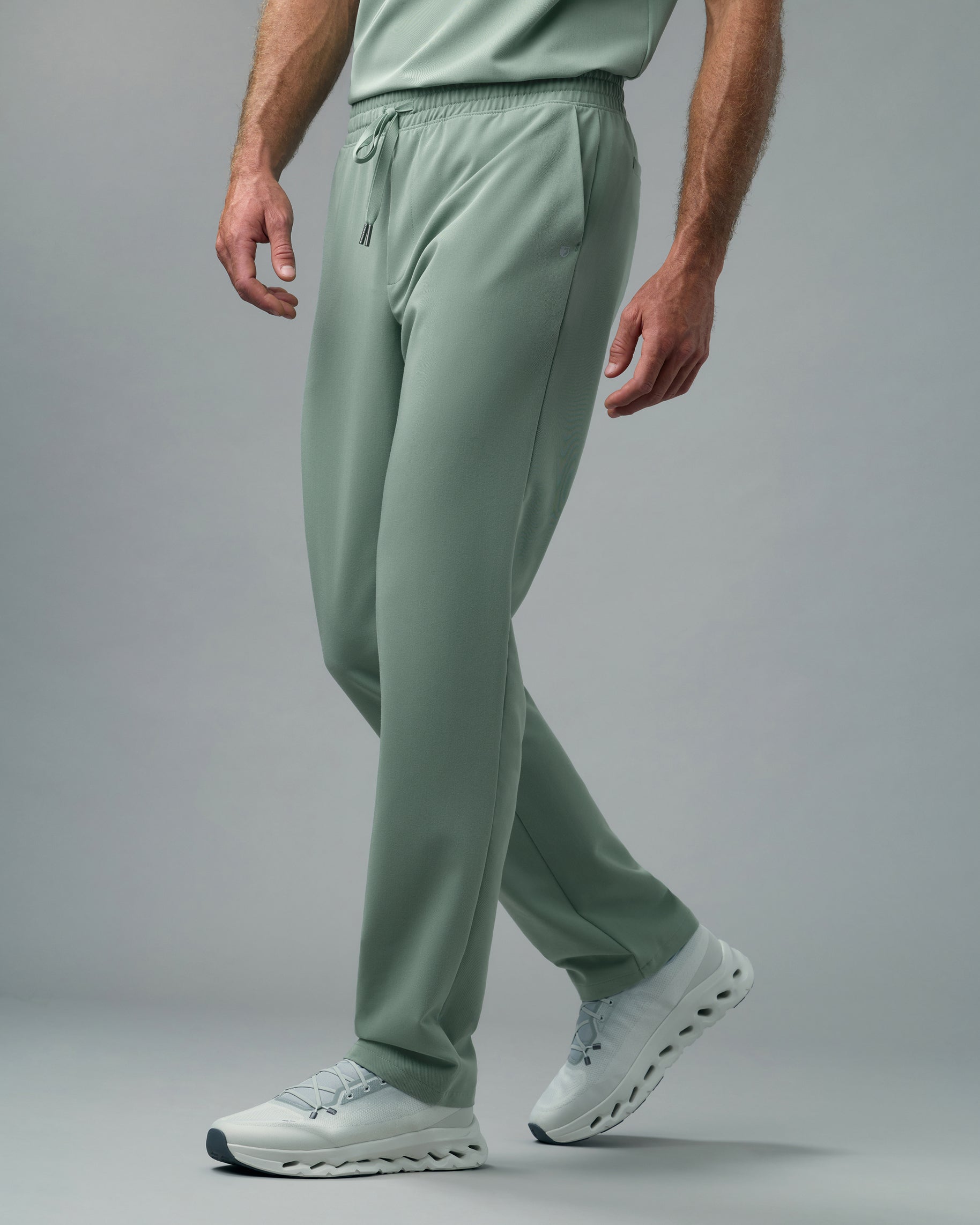 Man walking in sage green straight-leg scrub pants