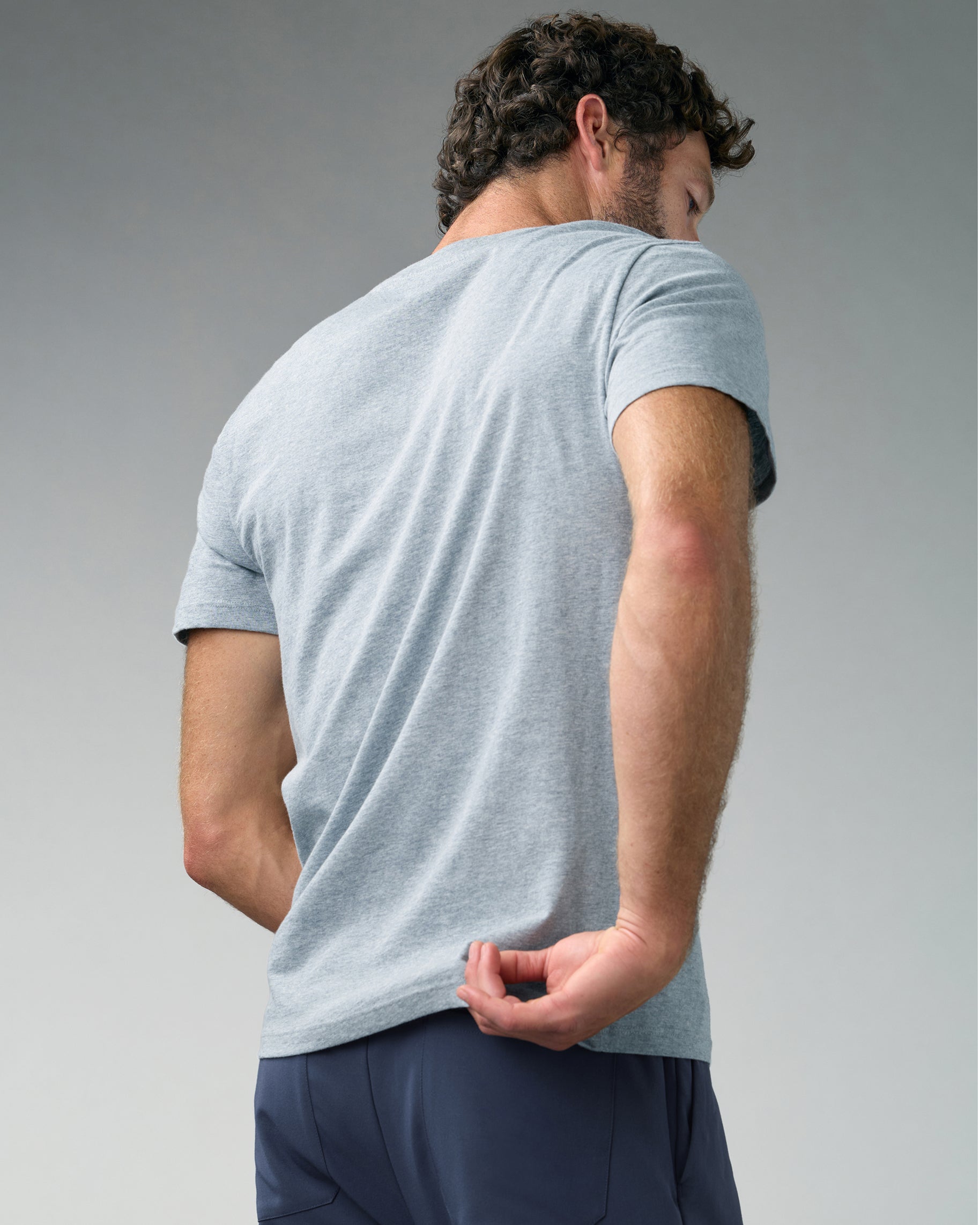Back view of a man in a heather gray short-sleeve underscrub and slate blue scrub pants