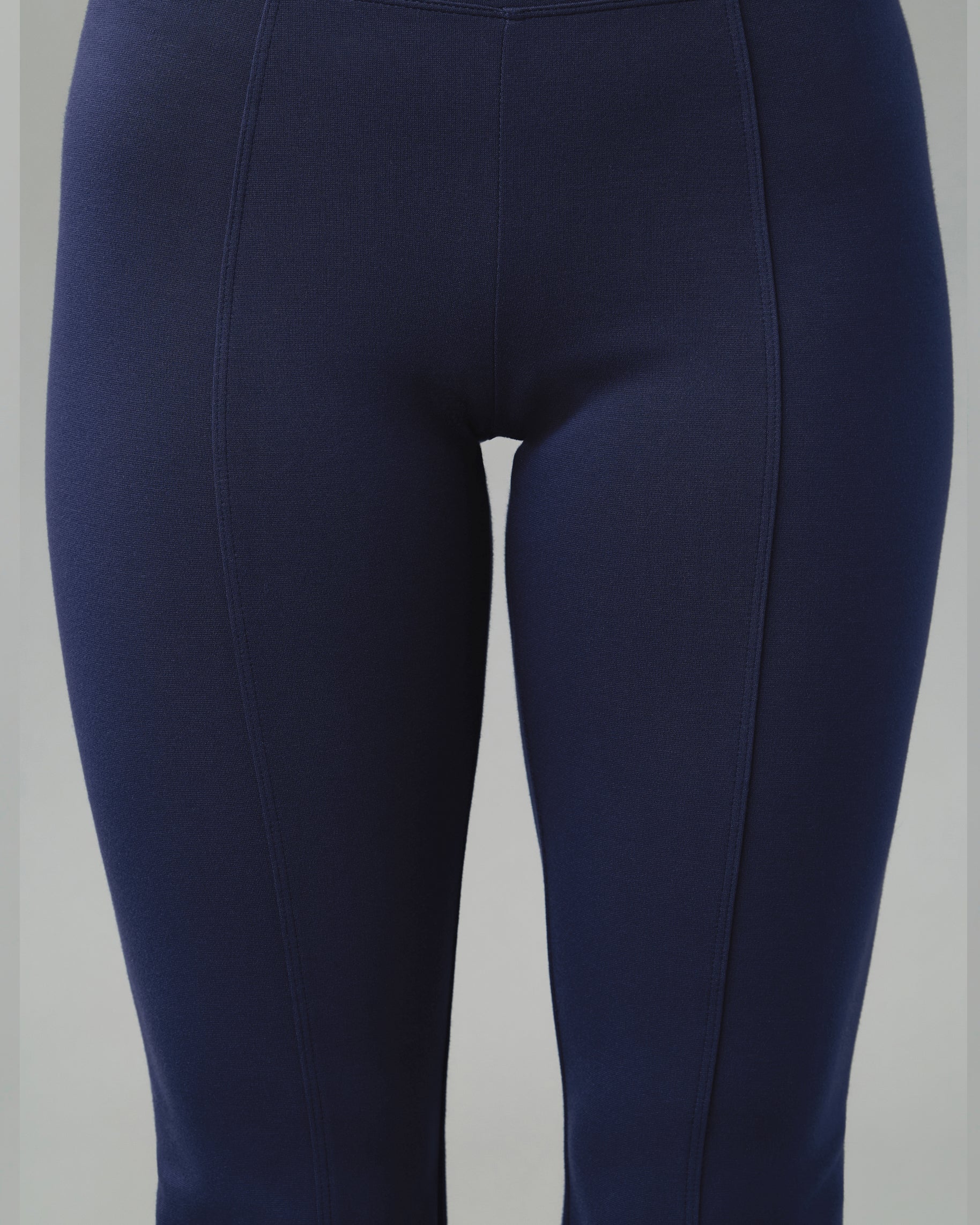 Close-up of the front seams running down the legs of navy yoga scrub pants