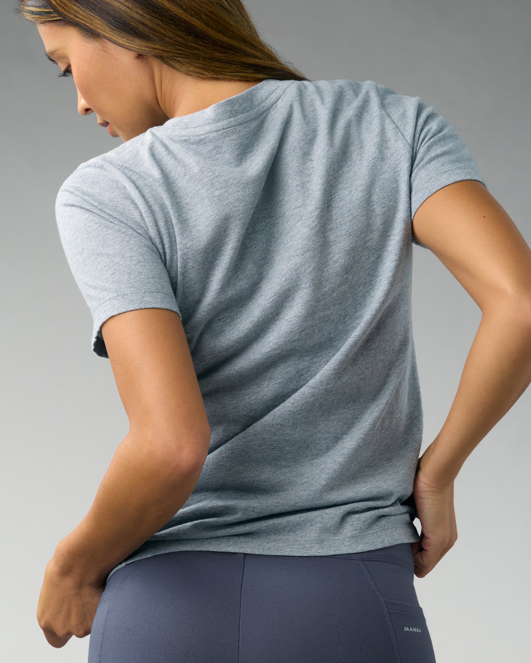 Back view of a woman in a heather gray short-sleeve underscrub and slate gray scrub pants