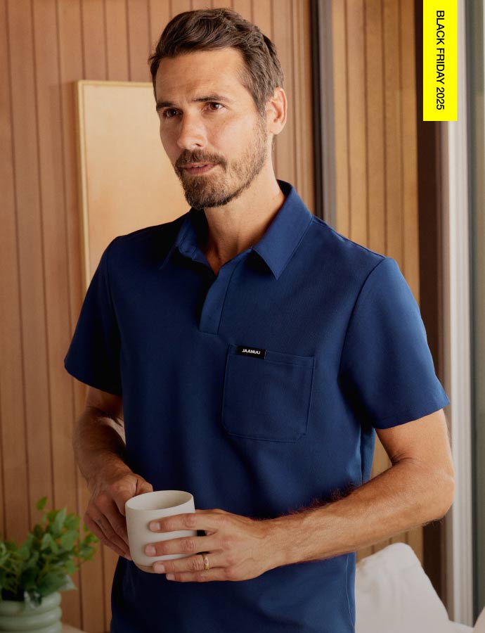 Image of man wearing a polo scrub top while holding a coffee mug. Image has text in the top right corner saying, "Black Friday 2025"