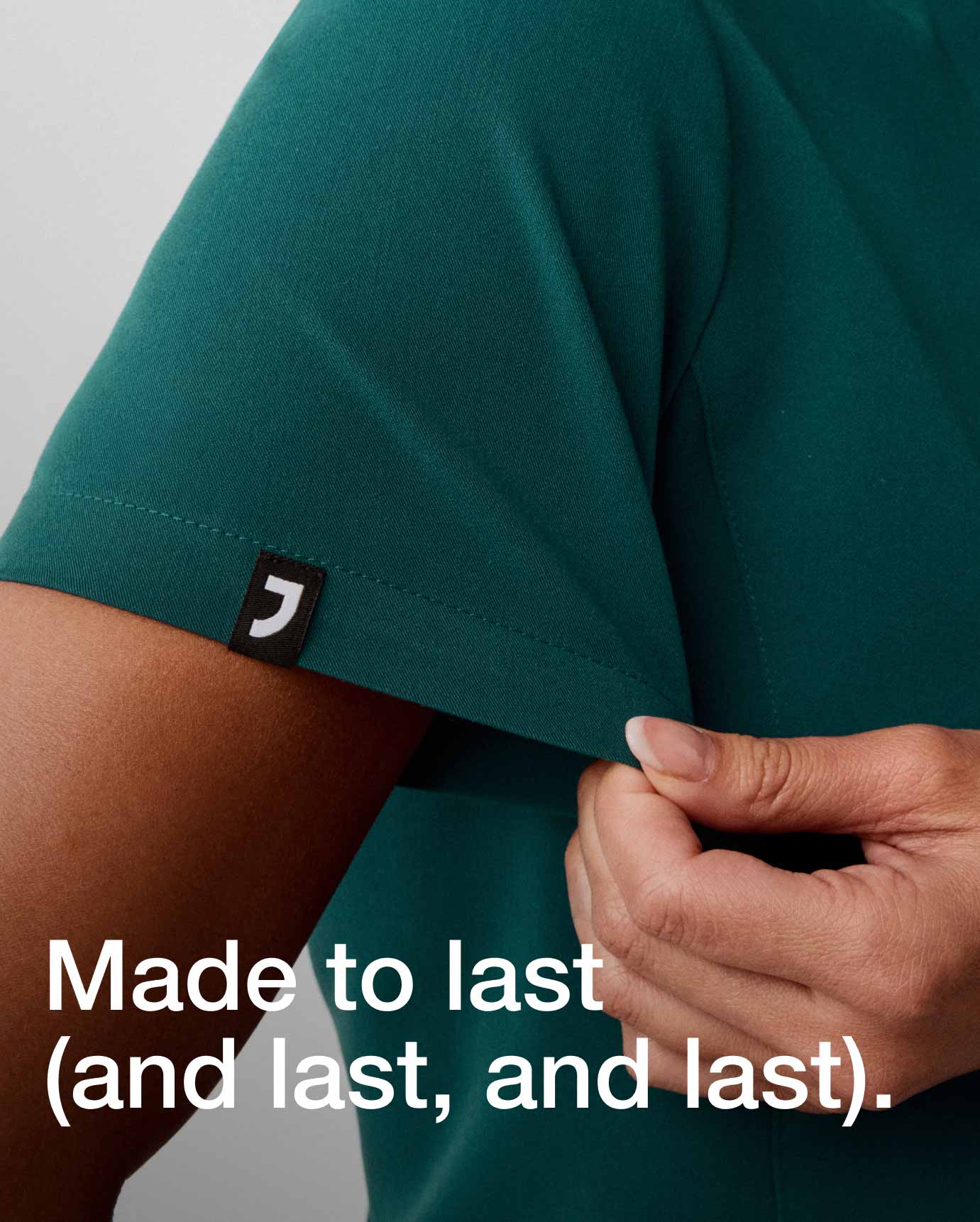 Image of someone holding a scrub top sleeve with text, "Made to last (last, and last).