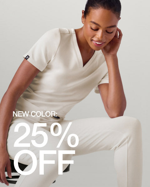 Woman wearing Frost color scrubs. Image has text, "New Color: 25% Off". - Women Nav Tile