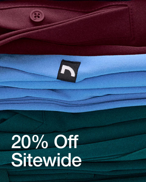 A stack of folded scrubs and scrub jackets stacked on top of each other. Image has text, "20% Off Sitewide". - Women Nav Tile