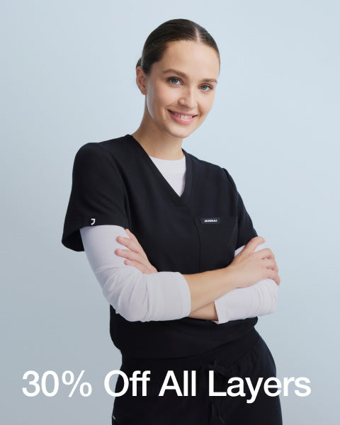 Image of a woman wearing a JAANUU underscrub with text saying, "30% Off All Layers" - Women Nav Tile