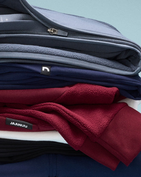 Image of folded JAANUU jackets stacked on top of each other. - Women Nav Tile