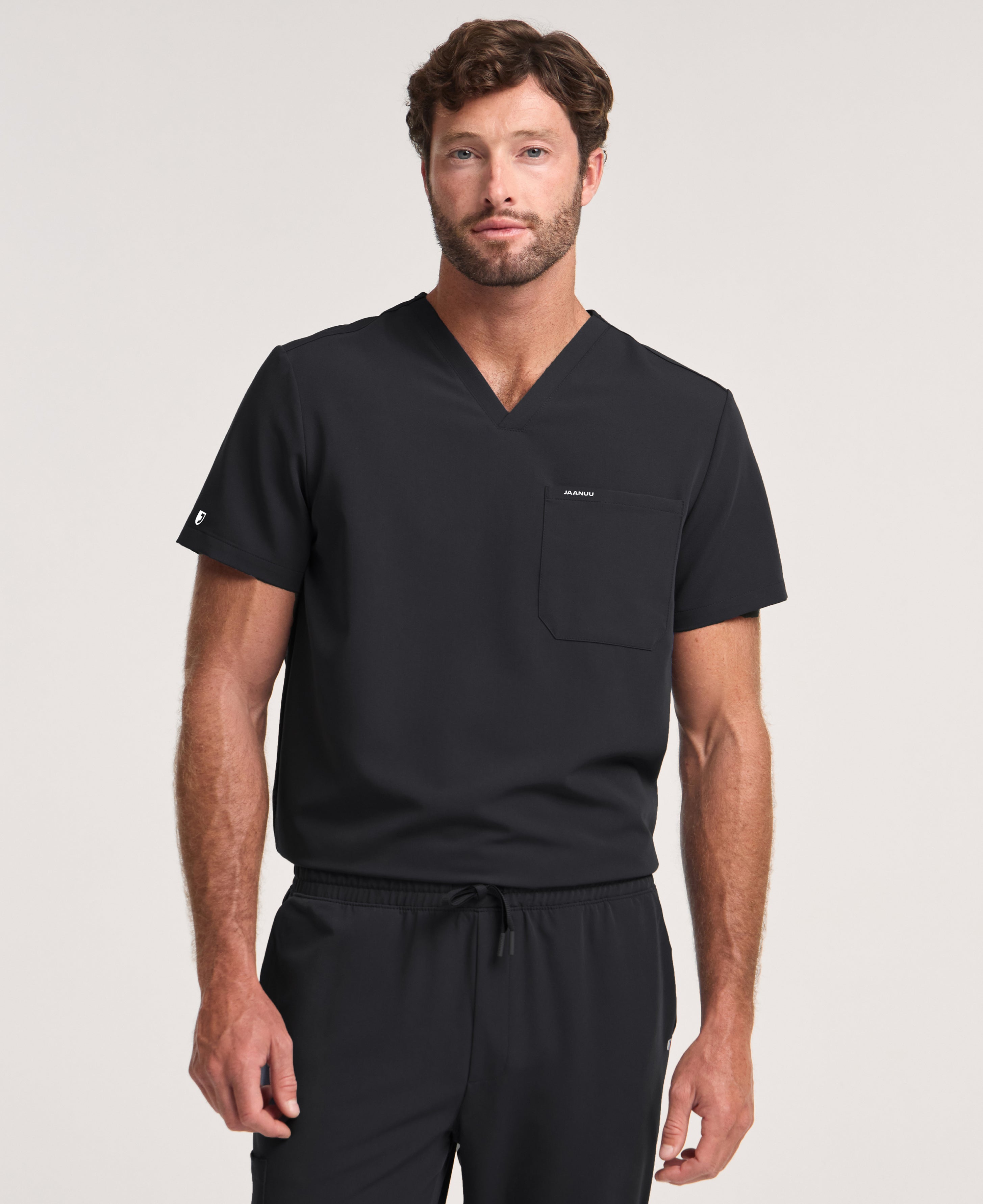 Jaanuu Holmes 1-Pocket Scrub Top in Black, product photo 1 of 6