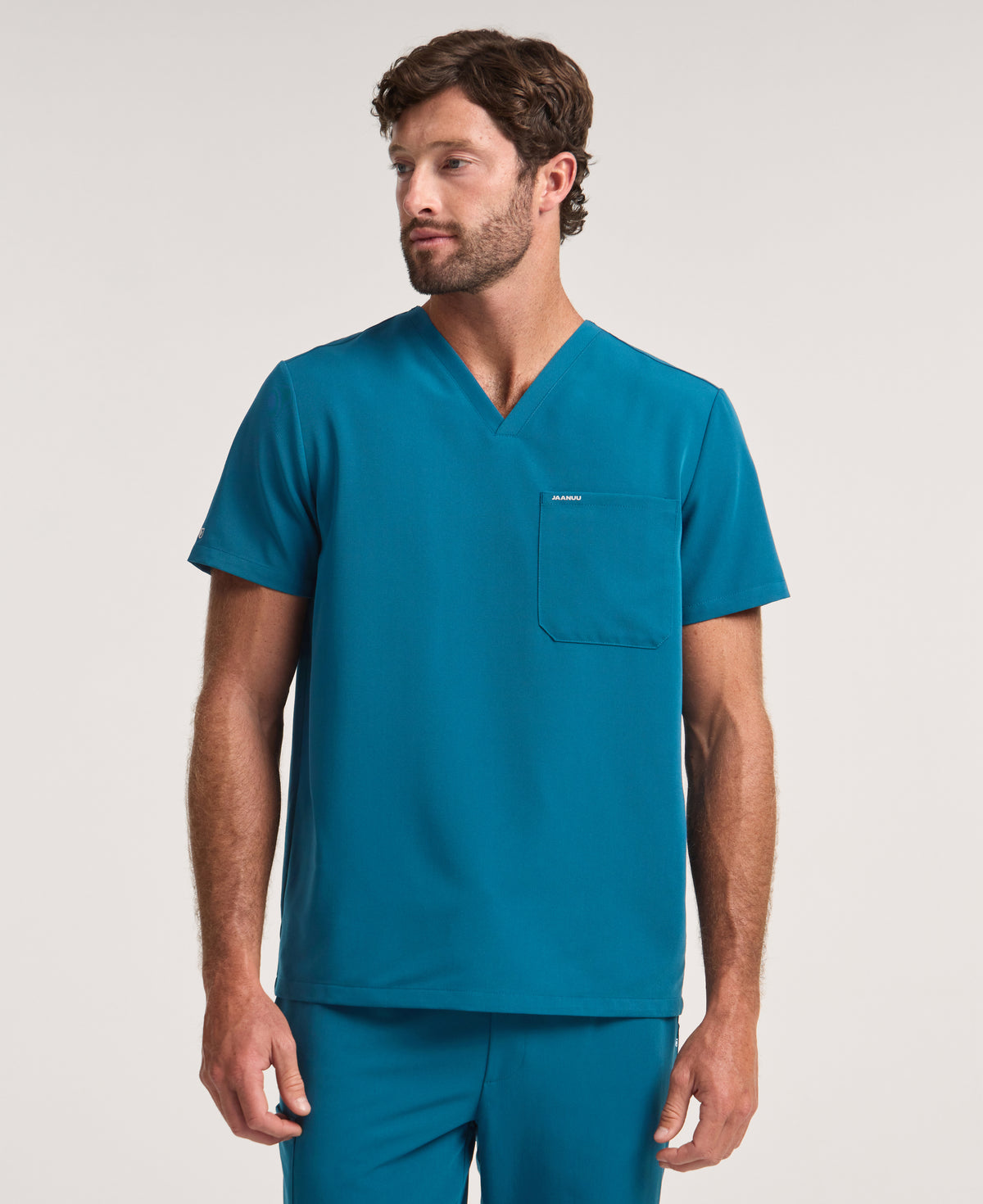 Jaanuu Holmes 1-Pocket Scrub Top in Caribbean Blue, product photo 1 of 6